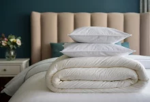 На кровати лежат одеяло и 2 подушки