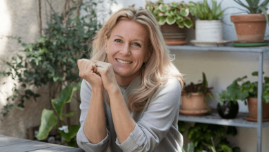 Жінка склала руки поруч з обличчям і сидить за столом