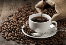 Чашка кофе и кофейные зерна рядом