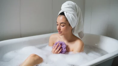 Дівчина приймає душ з мочалкою