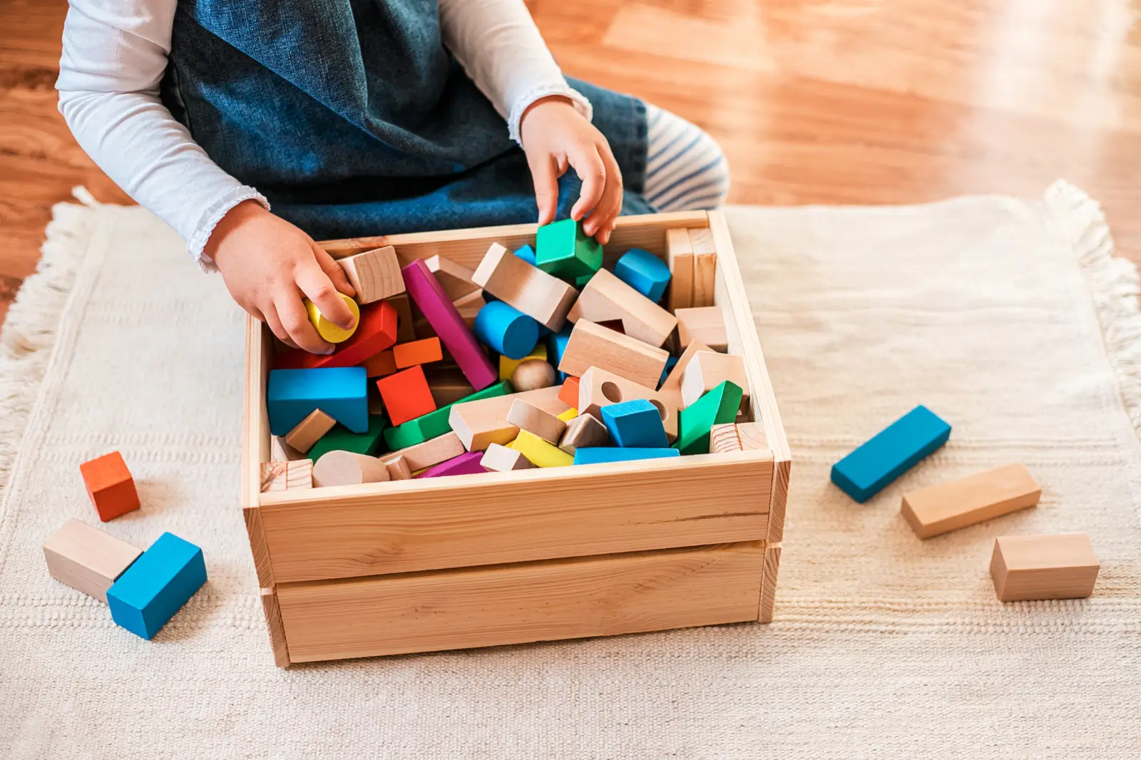 Хлопчик складає іграшки в кошик