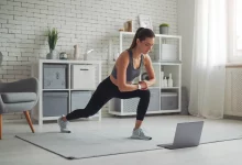 Дівчина робить спортивний комплекс вправ дивлячись у ноутбук