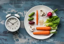 Будильник и овощи в тарелке