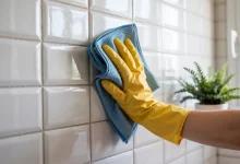 Протирает плитку тряпкой