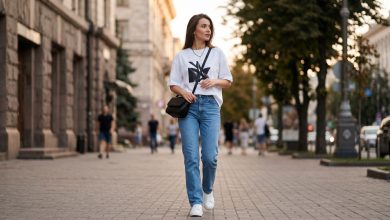 Елегантний літній образ 2026: жінка демонструє модну футболку в повсякденному стилі на фоні міського парку.